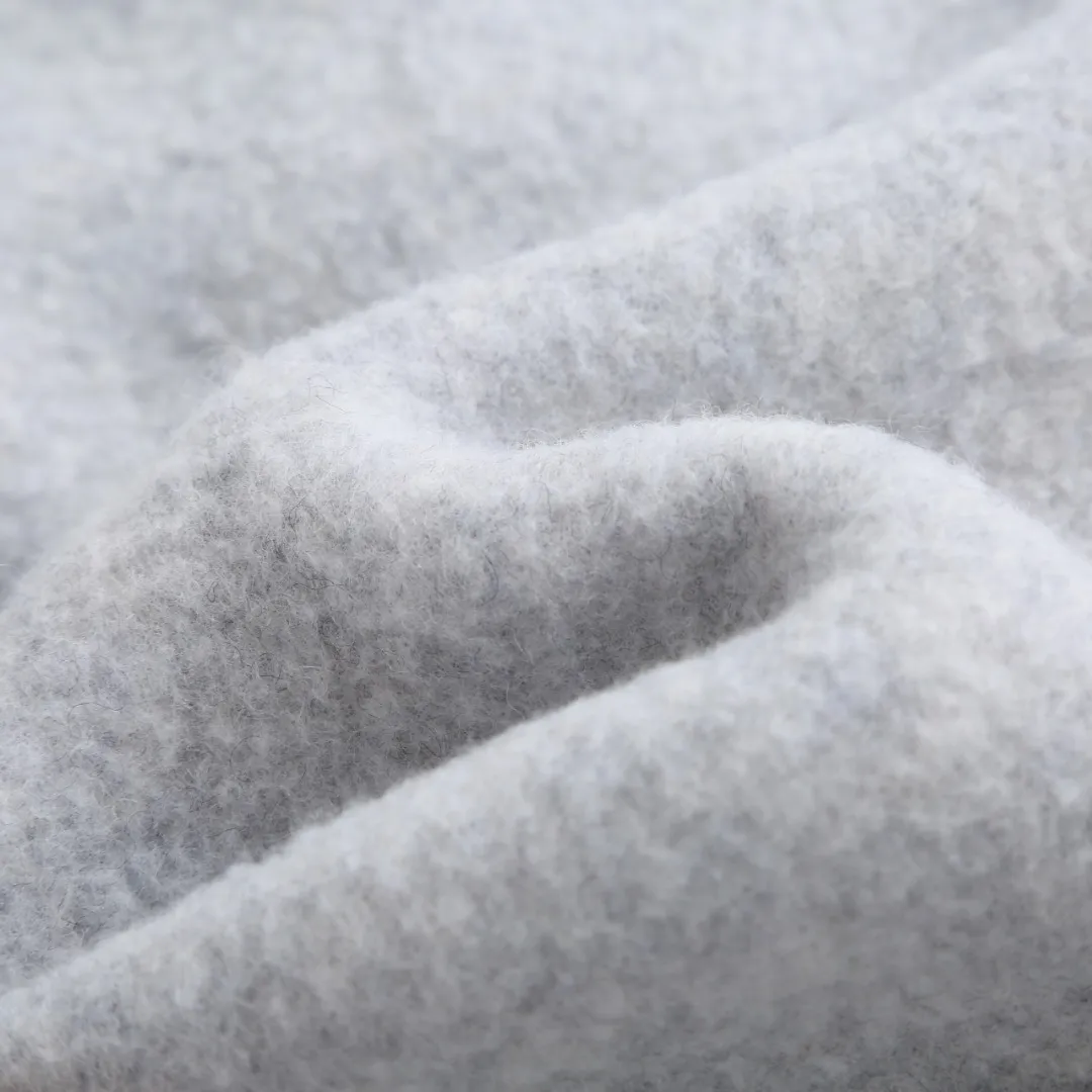 P760 Canada Goose Fleece Badge Button Jacket Fabric selection: Wool blend fabric: The main fabric of this jacket is light gray wool blend fabric to improve the fabric's wear resistance, wrinkle resistance and warmth. Wool provides good warmth and a natural feel, while blended fibers enhance the fabric's practicality and durability.  RIBBED KNIT: The collar, cuffs and hem are ribbed knitted for added stretch and fit.  Production process: The cutting process needs to ensure that the texture and color of the fabric are evenly distributed, especially for this light gray tone, to avoid color differences. The stretchability of wool-blend fabrics needs to be taken into consideration when cutting pieces to ensure dimensional stability of the finished garment.      • Use a sewing needle and thread suitable for wool-blend fabrics to avoid damage to the fabric during sewing. The sewing stitches are even and firm to prevent thread stripping.      • The temperature needs to be controlled during ironing to avoid high temperature damage to the fabric while keeping the fabric smooth and crisp.  Main body splicing: • The front and back body parts, sleeves and other main parts are spliced ​​with flat seams to ensure a smooth silhouette. •Align the fabric texture at the splicing points to keep the appearance neat.     Details such as pockets and cuffs are designed with inset pockets to increase practicality and aesthetics.     The splicing areas are reinforced to improve durability.  Armband: The white round armband on the left arm is an important part of the brand identity and is finely sewn to ensure it is strong and flat.  Dark gray and light gray Size: S M L XL